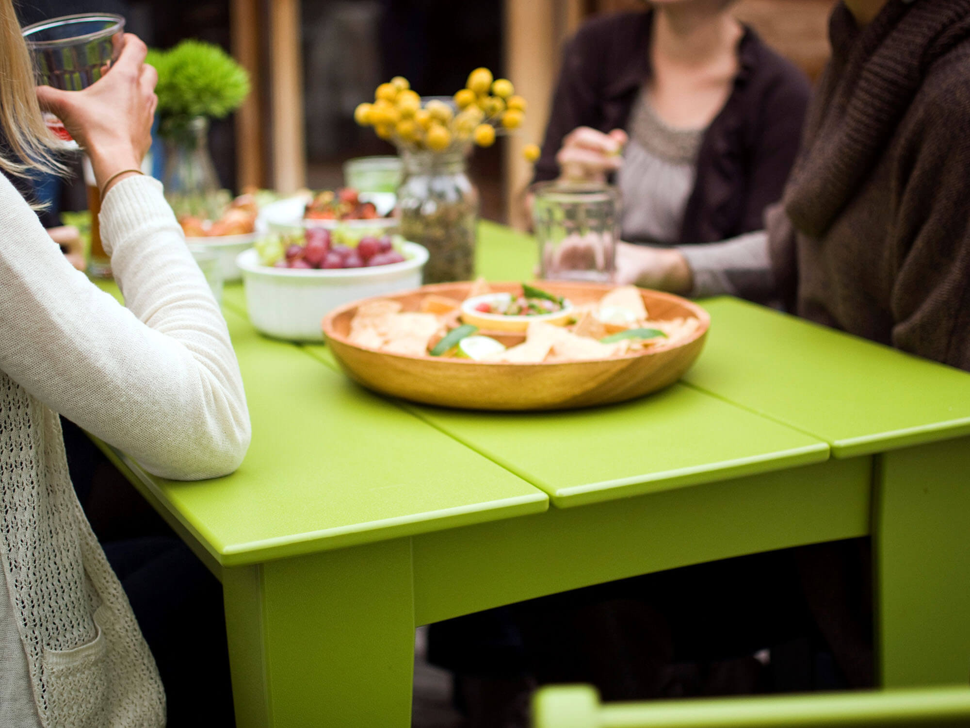 People gathered for snacks around a green outdoor table